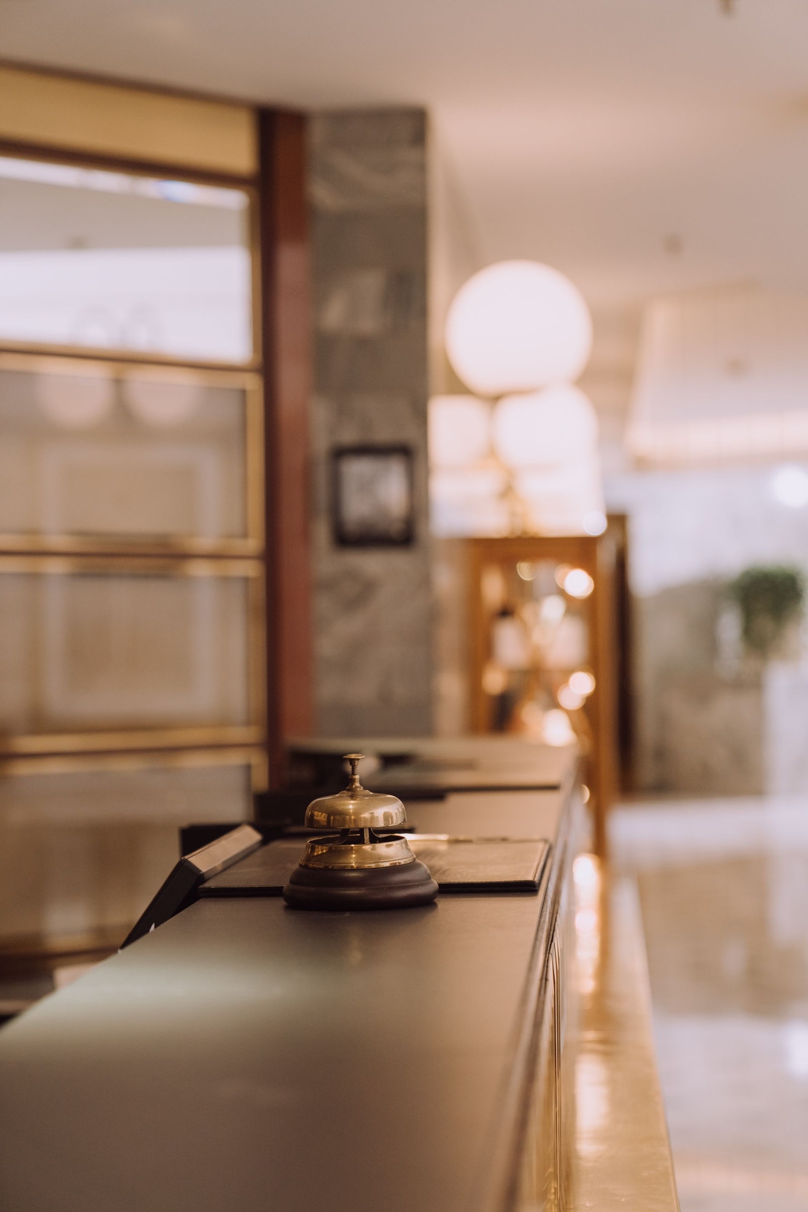 An unanswered reception bell on a hotel front desk